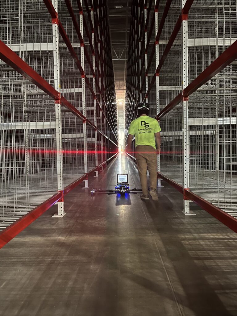 Durable Surfaces employee walking aisles with profilograph to measure floor flatness