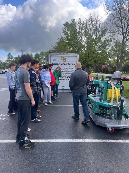 Students listening to a career presentation outside by Durable Surfaces