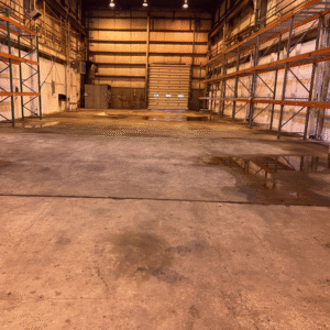 Damaged warehouse concrete floor in loading doc area.